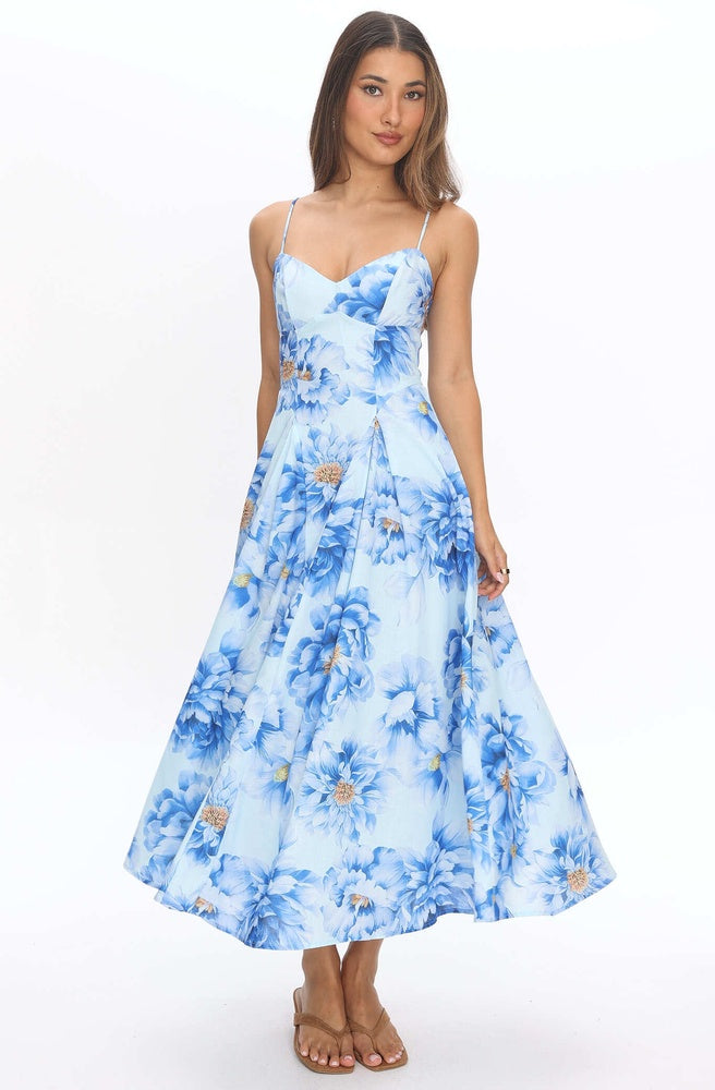 Model wearing Tonketti Blue Peony slip maxi dress with soft blue floral print and flowing A-line skirt.