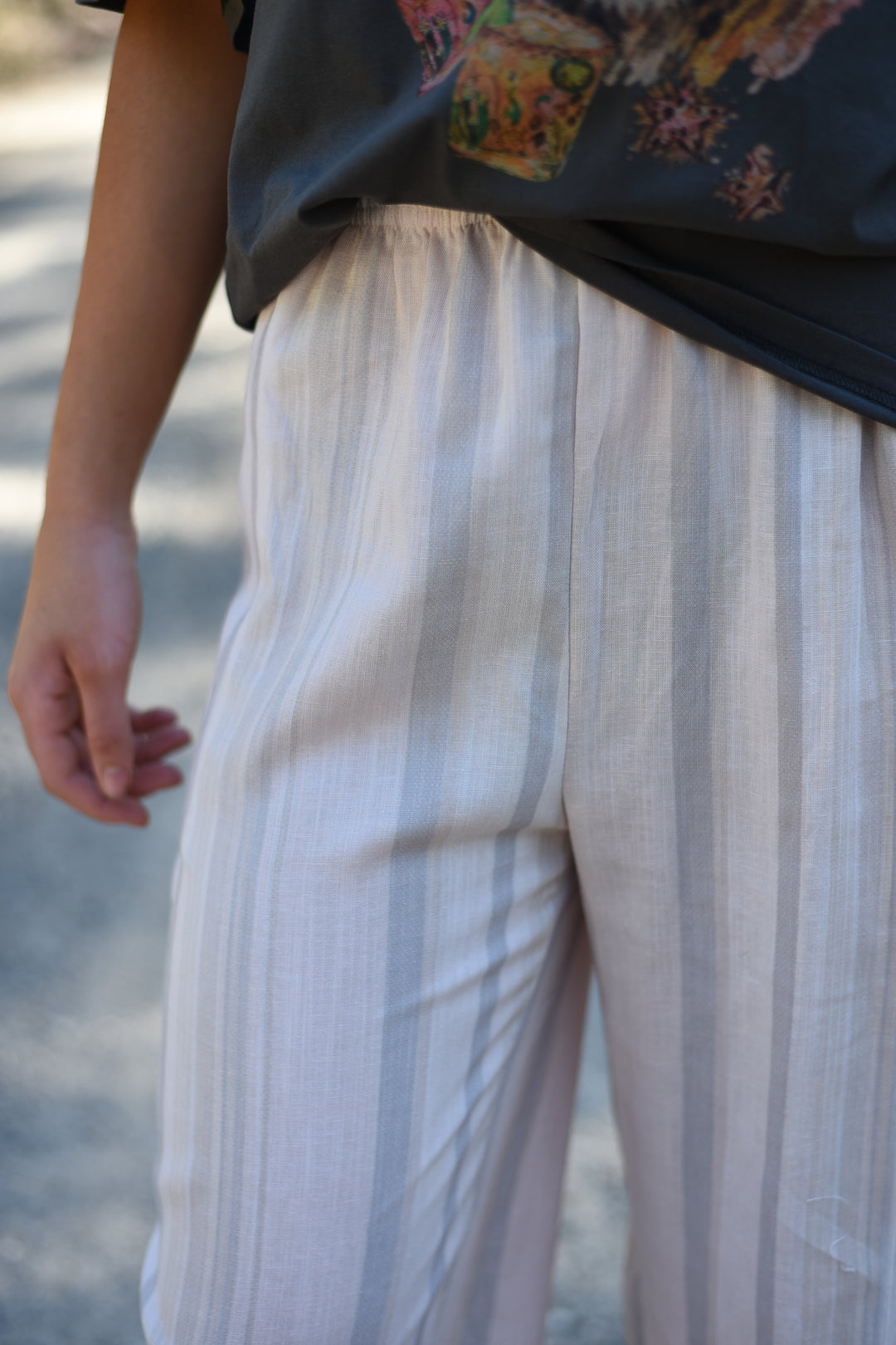 Close-up of the Blush Horizon Stripe Pants showing the lightweight striped fabric and elastic waistband.