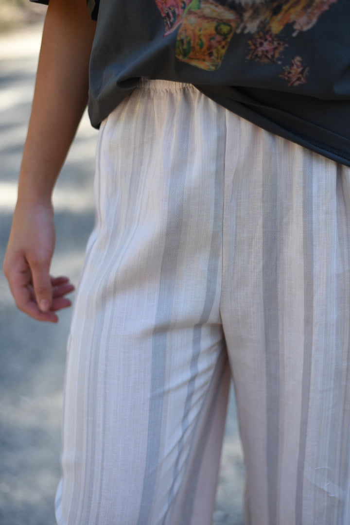 Close-up of the Blush Horizon Stripe Pants showing the lightweight striped fabric and elastic waistband.