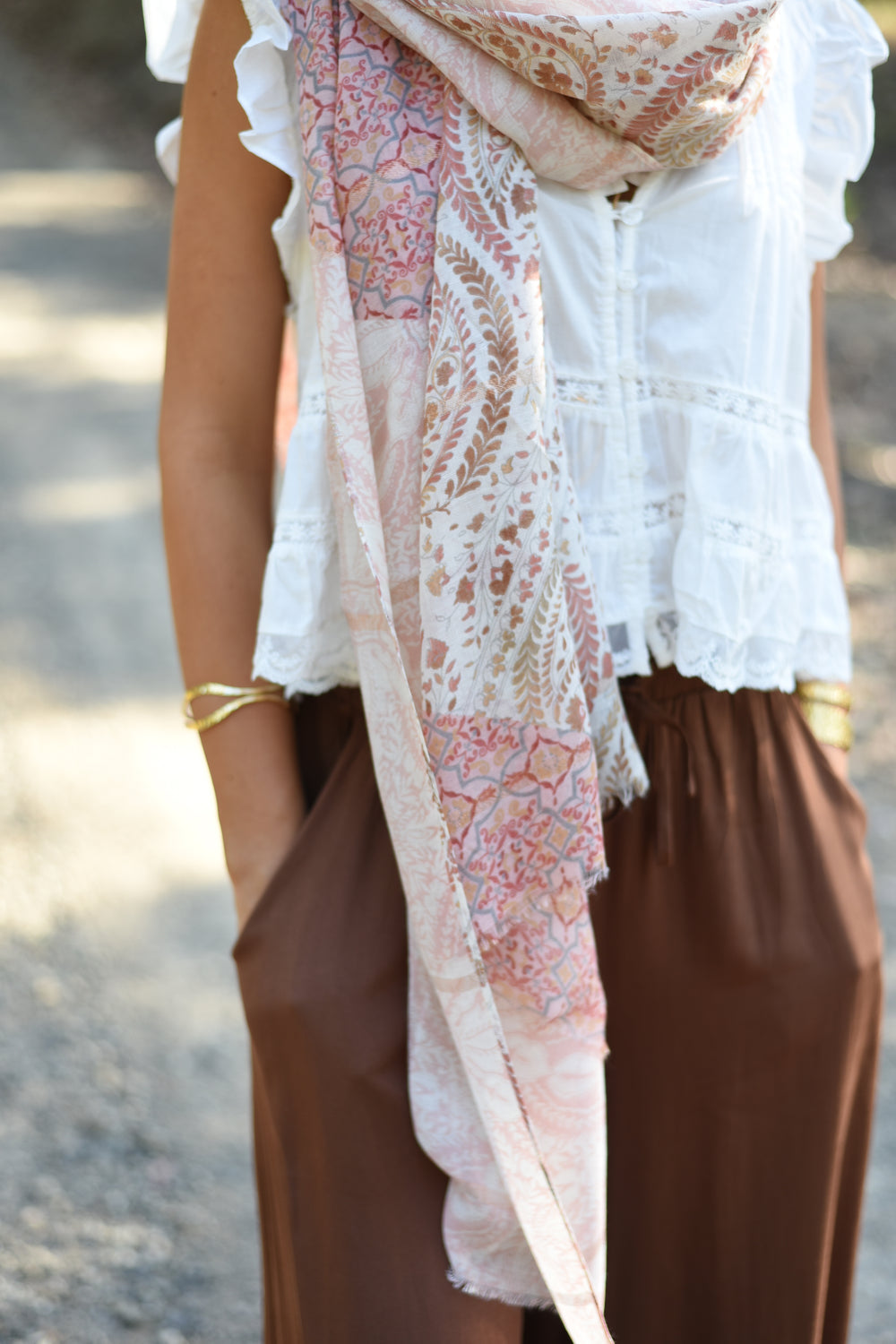 Honey styling the Blush Paisley Scarf loosely around her neck with a white blouse.