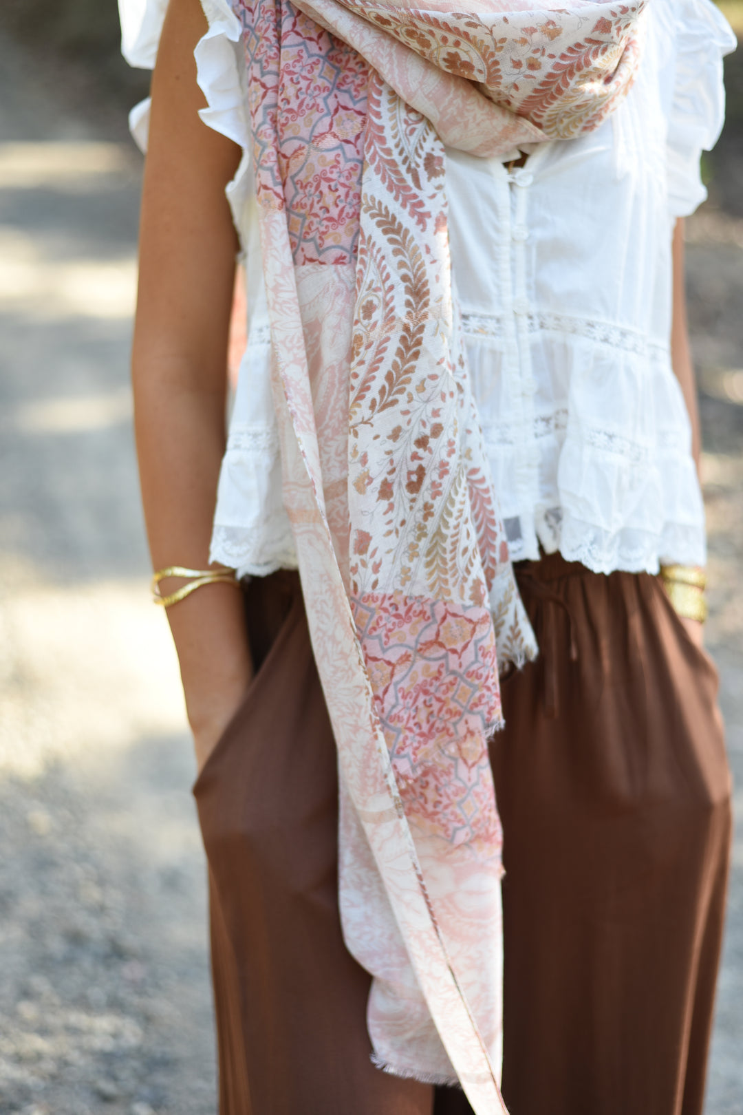 Honey styling the Blush Paisley Scarf loosely around her neck with a white blouse.