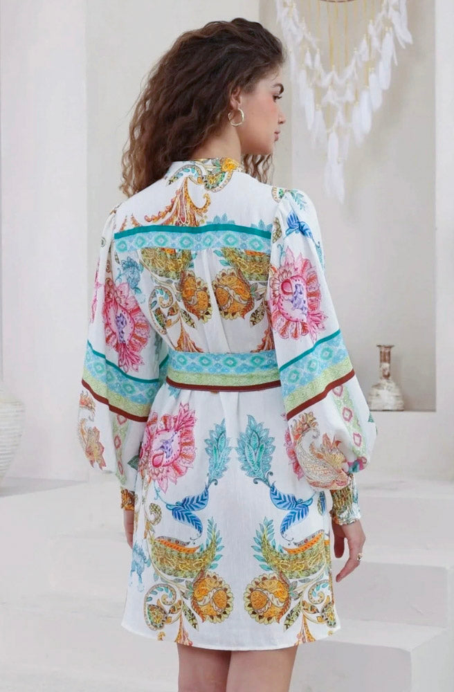 Calipso Bloom long sleeve mini dress featuring a vibrant floral print, button bodice, and long billowy sleeves