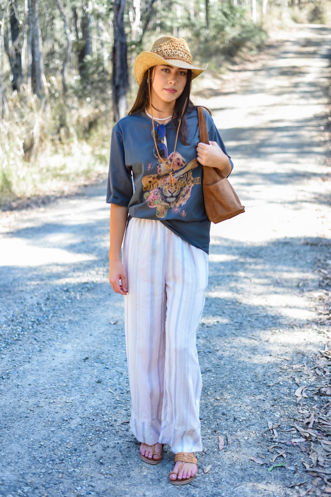 Charcoal Last Call Tee styled with white wide-leg pants and a straw cowboy hat for a relaxed western-boho outfit. Paired with Crochet Tan Sun Hat