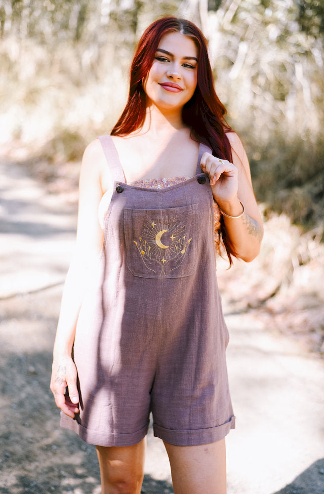 Choc Gift Manifest Overalls in mocha textured cotton featuring celestial embroidery, adjustable shoulder straps and rolled hems.