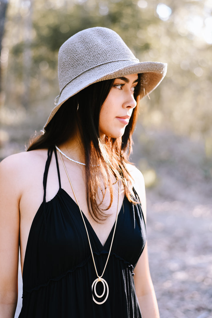 Honey wearing the Classic Almond Bucket Hat with a relaxed black summer outfit.