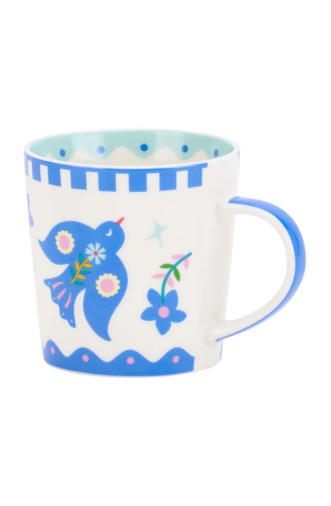 Coffee Mug – Fiesta Bird featuring a blue bird and colourful floral illustrations.