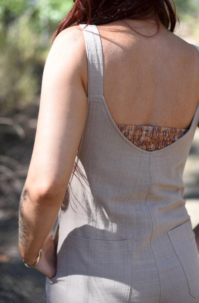Back view of the Cream Manifest Overalls showing the adjustable shoulder straps, relaxed fit and functional back pockets.