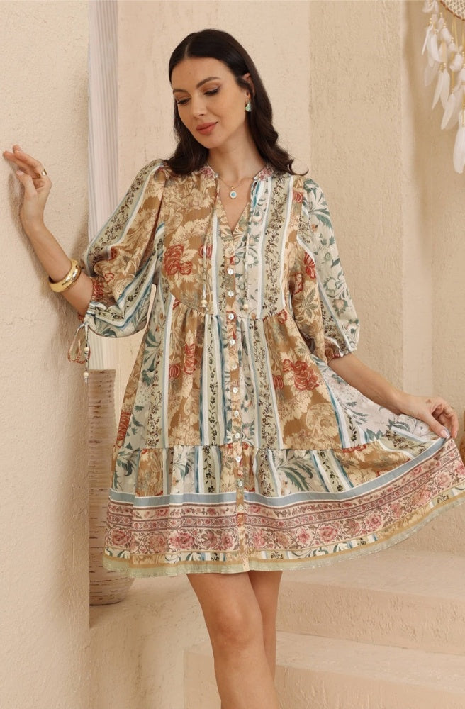 Desert Heirloom Babydoll Dress in earthy floral paisley print with tassel tie neckline and tiered skirt.