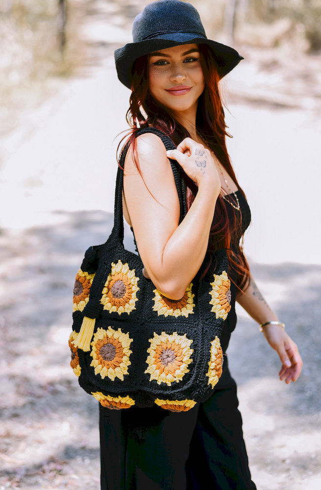 Eclipse Sun Crochet Bag in black with golden yellow and brown sunflower crochet panels and a decorative yellow tassel