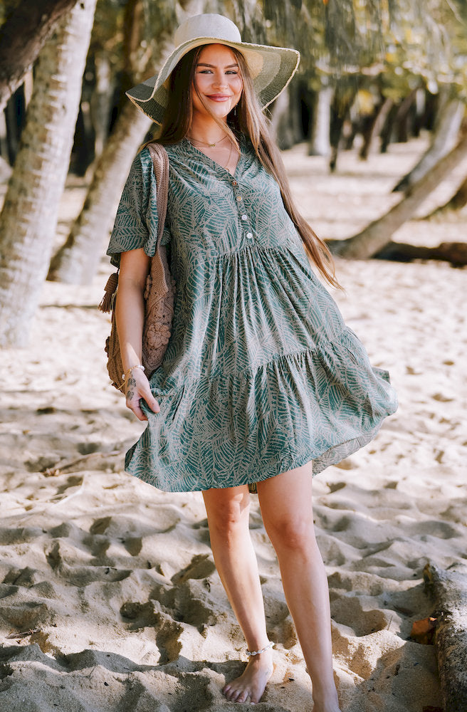 Forest Essence Cherry Dress featuring a green botanical print, button-front neckline and relaxed tiered mini silhouette