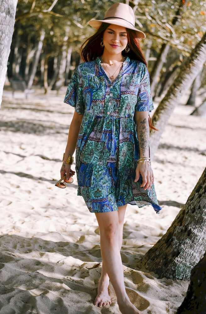 Forest Patch Cherry Mini Dress featuring a blue, sage and turquoise paisley patchwork print, relaxed tiered silhouette and short flutter sleeves.