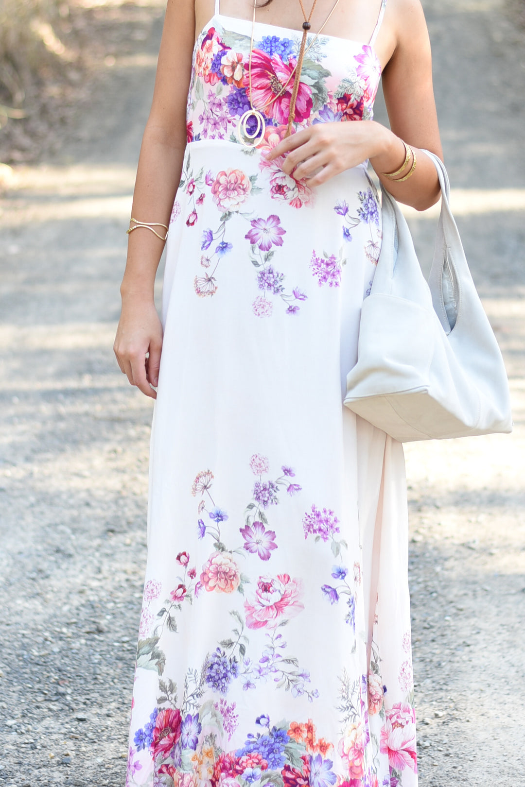 Close-up of the Garden Bloom Maxi Dress highlighting its vibrant floral print and soft white fabric.