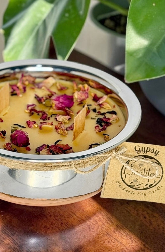 Gypsy Soy Candle in a silver bowl with dried rose petals, botanicals and warm earthy fragrance.