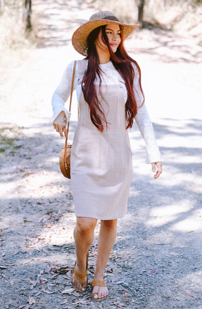 Gypsy Thread Pinafore Mid Short Cream featuring adjustable shoulder straps, a front bib pocket and a relaxed knee-length silhouette.