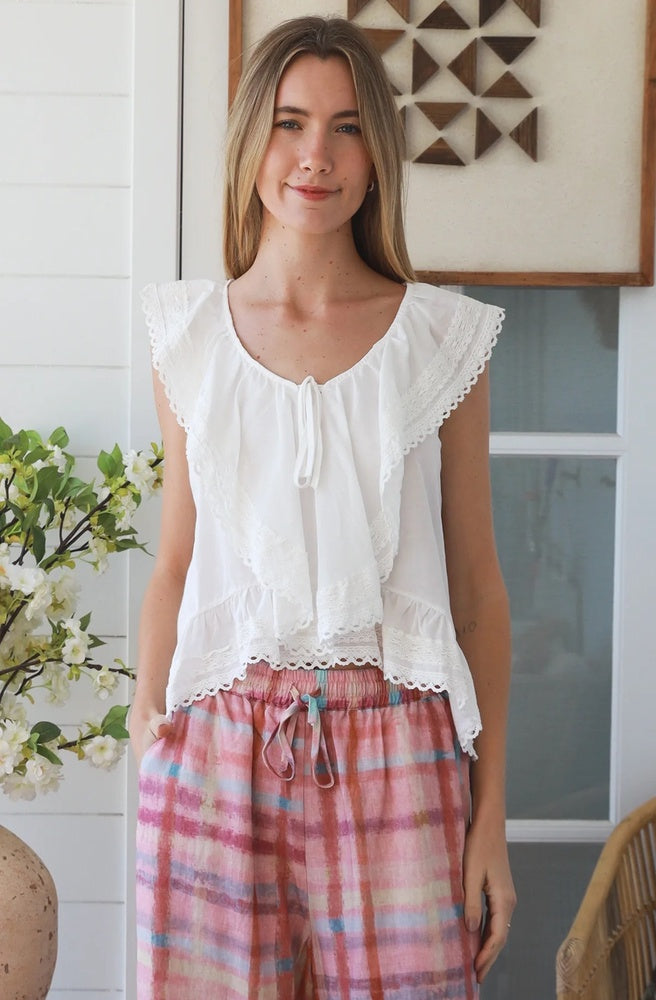 Ivory Pleated Peplum Top featuring a pleated V-neckline, flutter sleeves and lace-trimmed peplum hem.