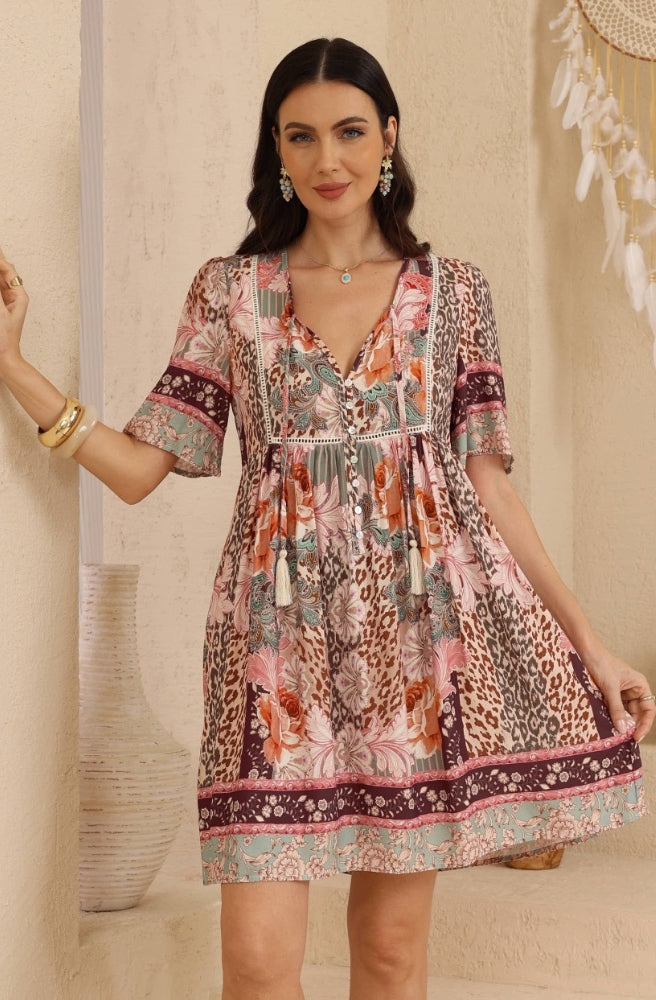 Back view of the Leopard Caravan Babydoll Dress showing its patchwork print, relaxed short sleeves and flowing babydoll silhouette.