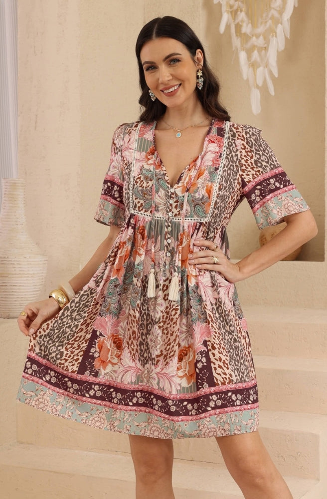Leopard Caravan Babydoll Dress featuring mixed leopard, paisley and floral prints, a button-front V-neckline and a gathered mini skirt.