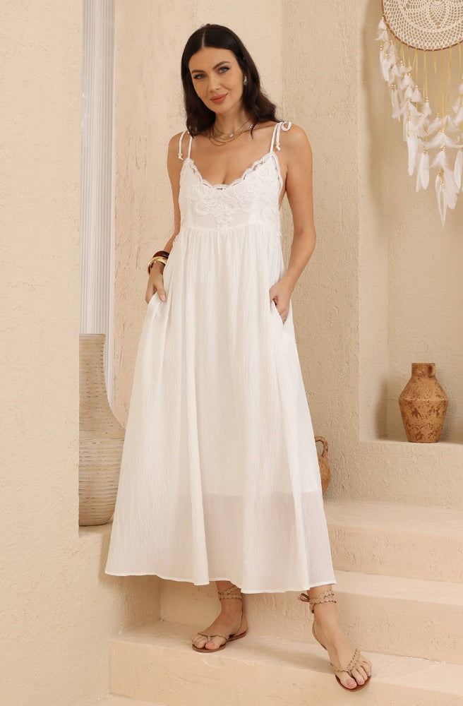Luna Cotton Lace Dress in white cotton with a delicate lace bodice, adjustable straps and flowing maxi silhouette.