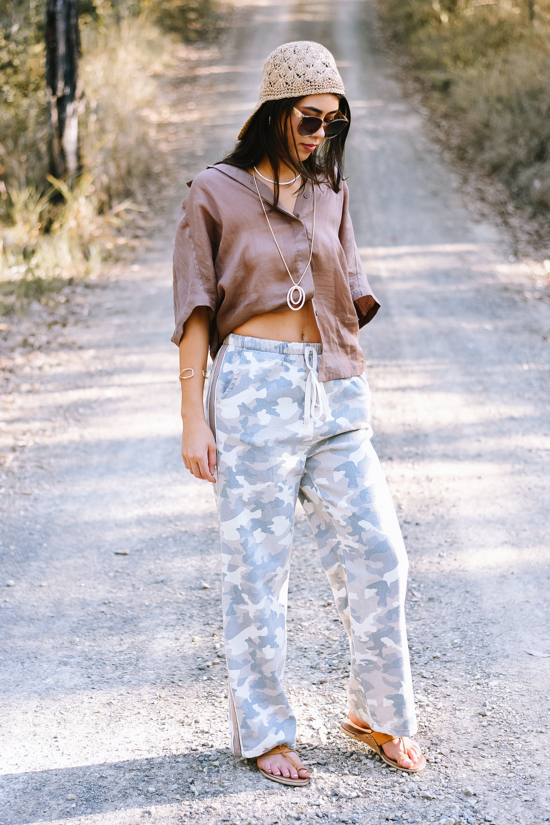 Front view of the Camo Racer Stripe Pants featuring a blue-grey camouflage print, elastic drawstring waist and contrasting taupe side stripes.