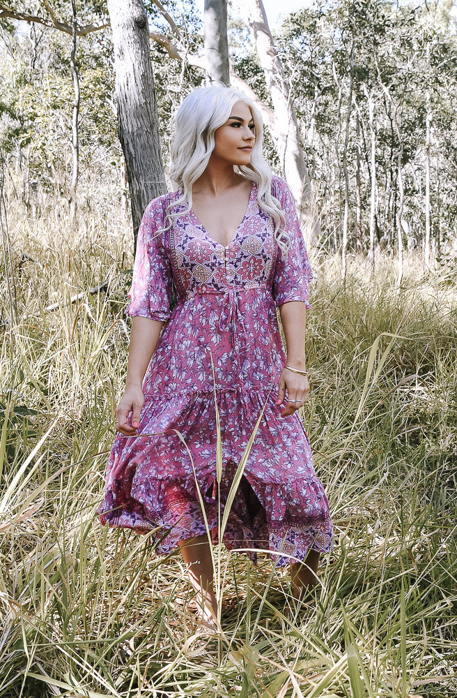 Mumbi Pink Nicki Midi Dress featuring a dreamy pink floral print, deep V neckline, drawstring waist and tiered frilled hem.