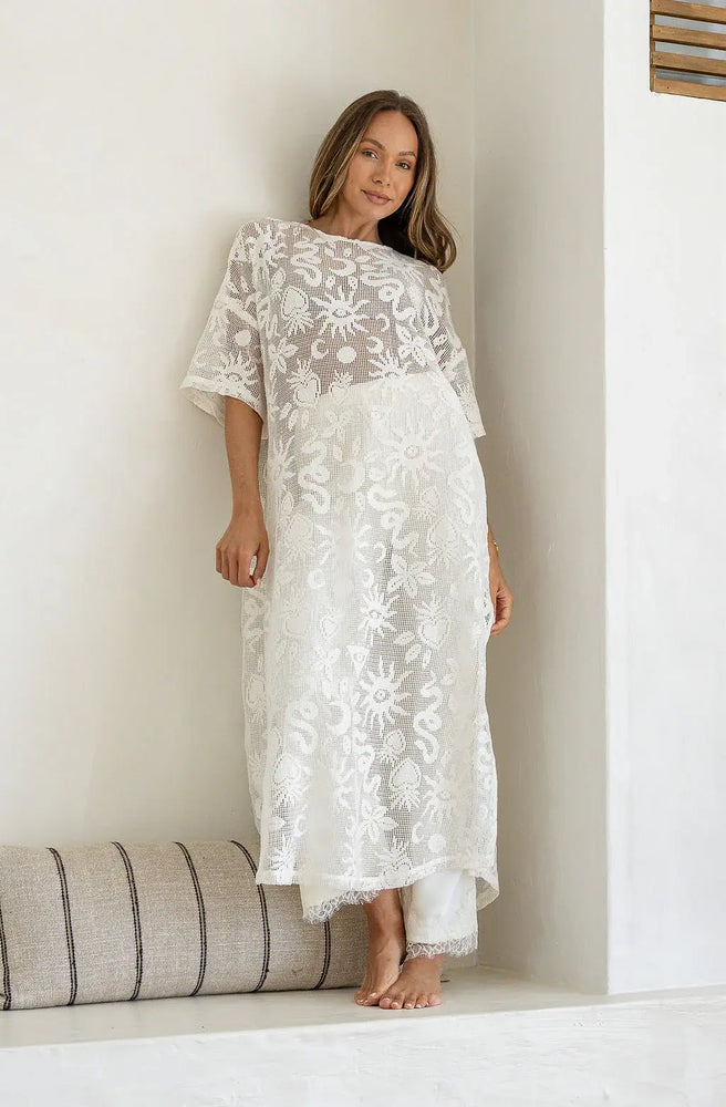 Elegant white lace shift dress featuring intricate floral lace, side splits, and a relaxed maxi-length fit.