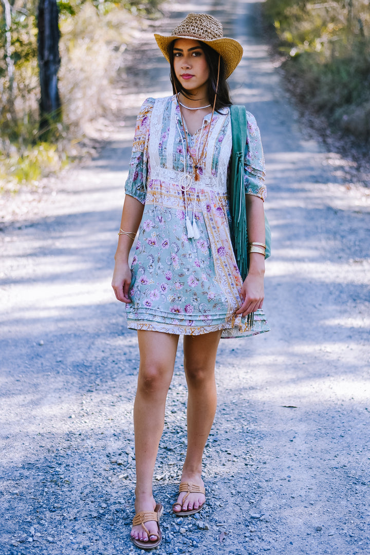 Front view of the Pastel Mosaic Lace Mini Dress in sage green with pastel floral prints, lace-trimmed bodice and puff sleeves.
