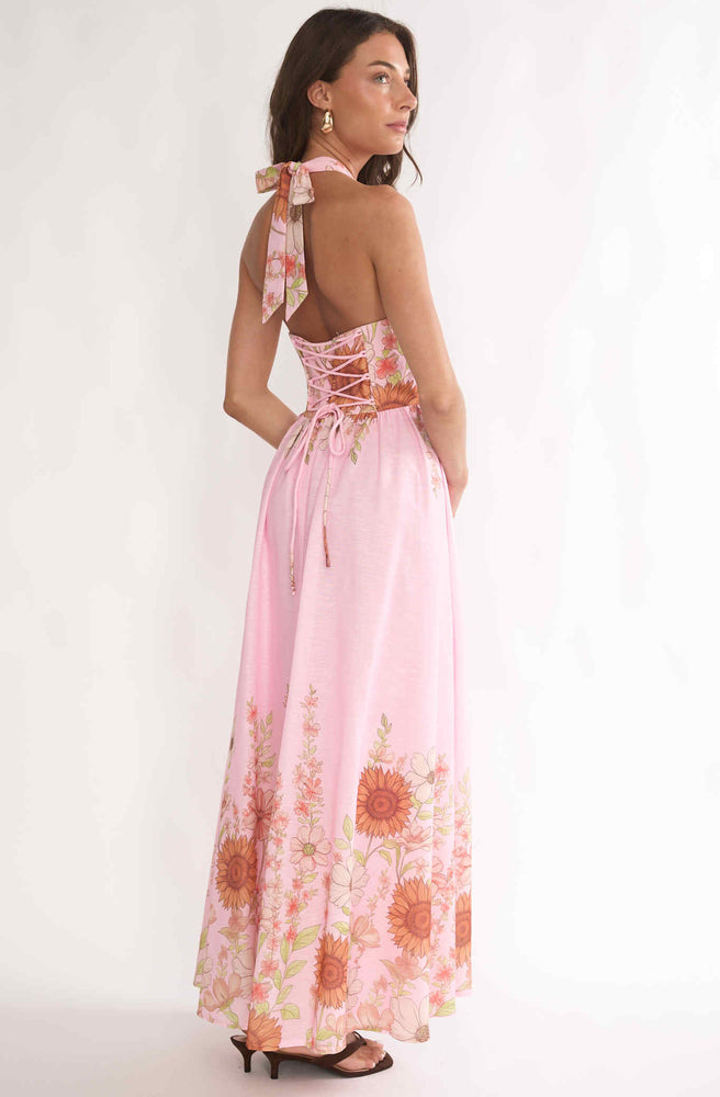 Back view of Tonketti Pink Petal halter maxi dress with lace-up back and pink floral border print.