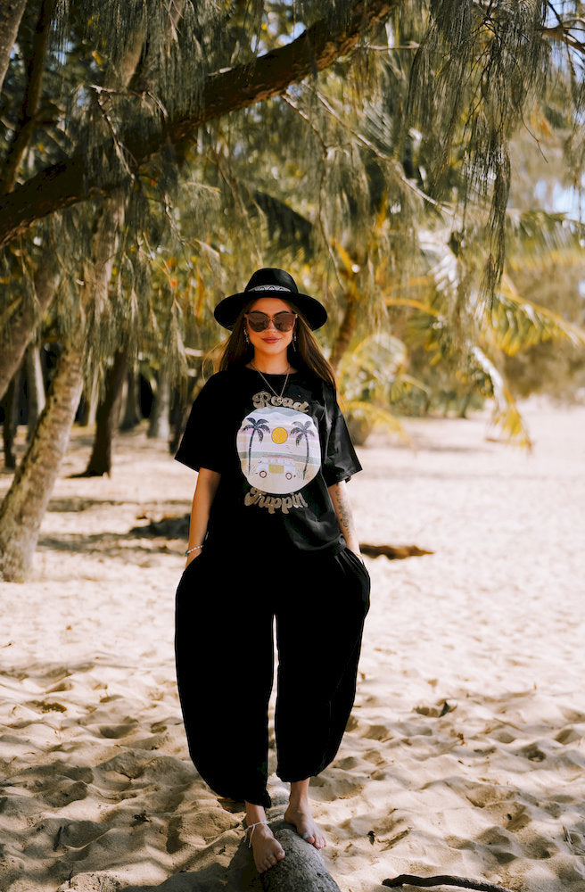 Women's Road Trippin Outlaw Tee featuring a retro beach graphic on a relaxed black organic cotton T-shirt