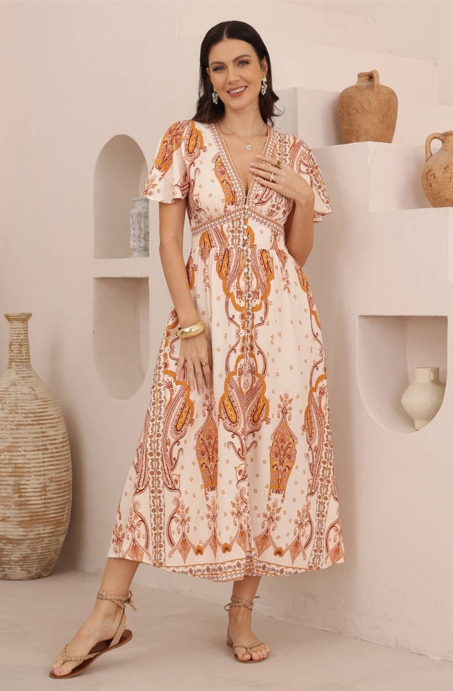 Sienna Paisley Maxi Dress in peachy ivory with rust and caramel paisley print, flutter sleeves and a flowing maxi skirt.