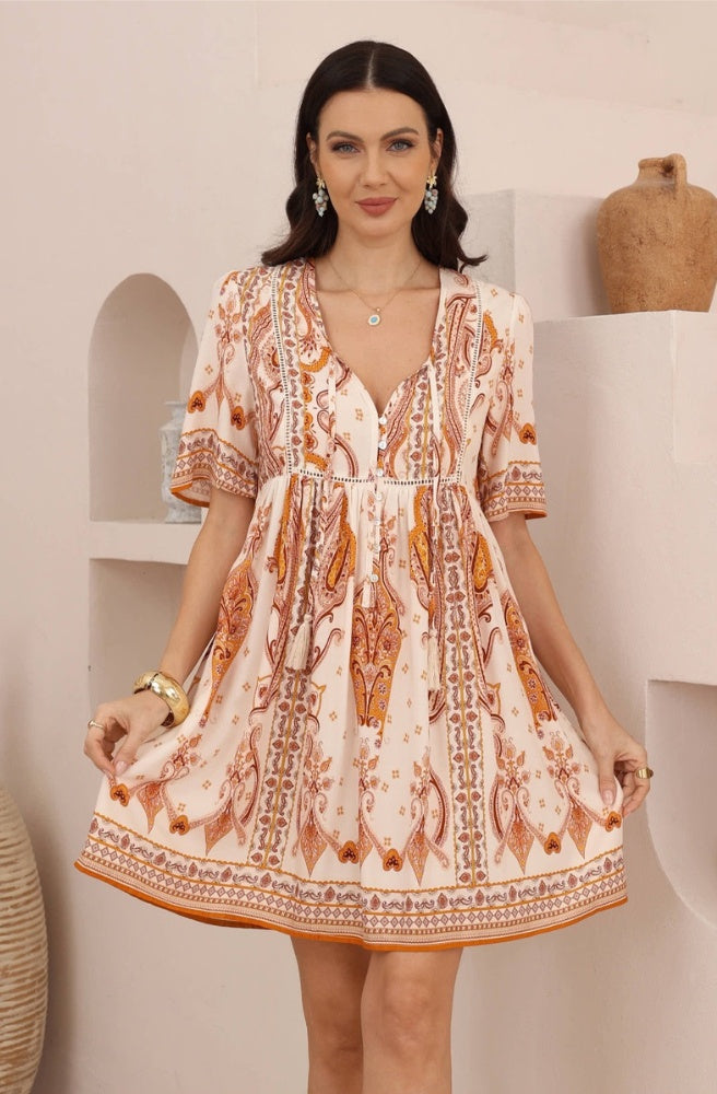 Sienna Paisley Mini Dress in peachy ivory with rust paisley print, short sleeves and a decorative border hem.