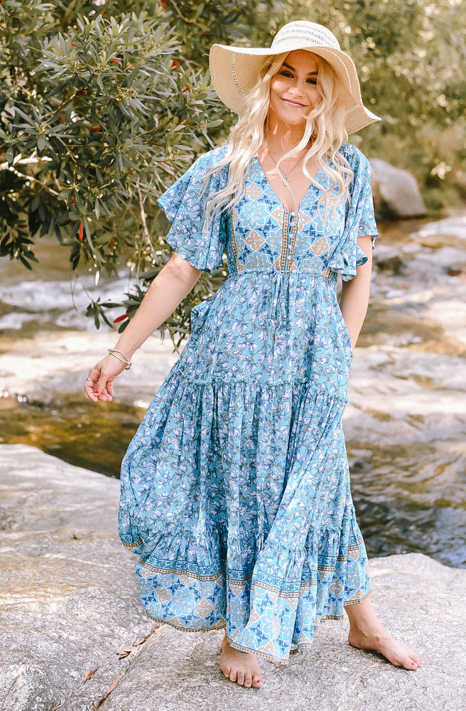 Turkish Tango Nicki Midi Dress featuring a blue floral print, V neckline, drawstring waist, wide sleeves and flowing ruffle hem.