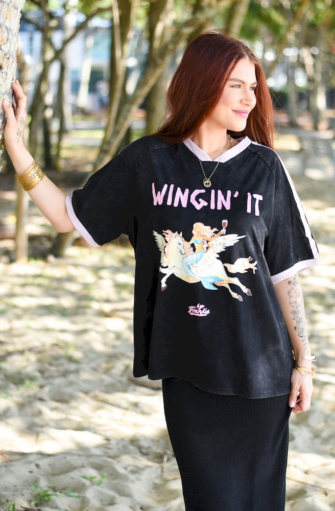 Wingin It Black Tee in black with pink WINGIN’ IT graphic, winged horse print and contrast trims.