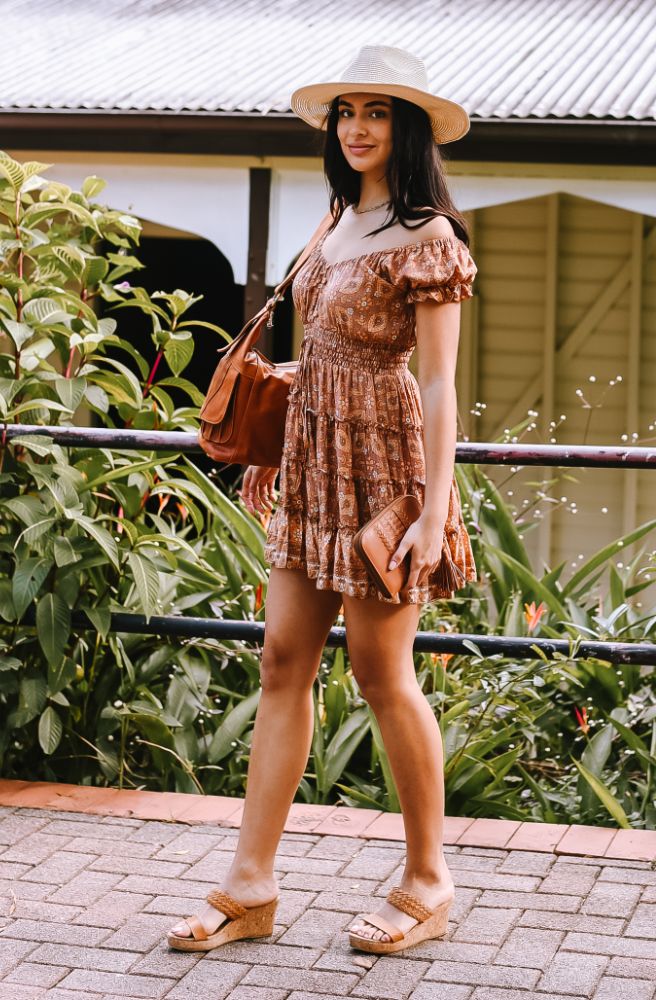 Brown Bayou Maggie Dress featuring a burnt orange boho floral print, shirred waist and tiered mini skirt.